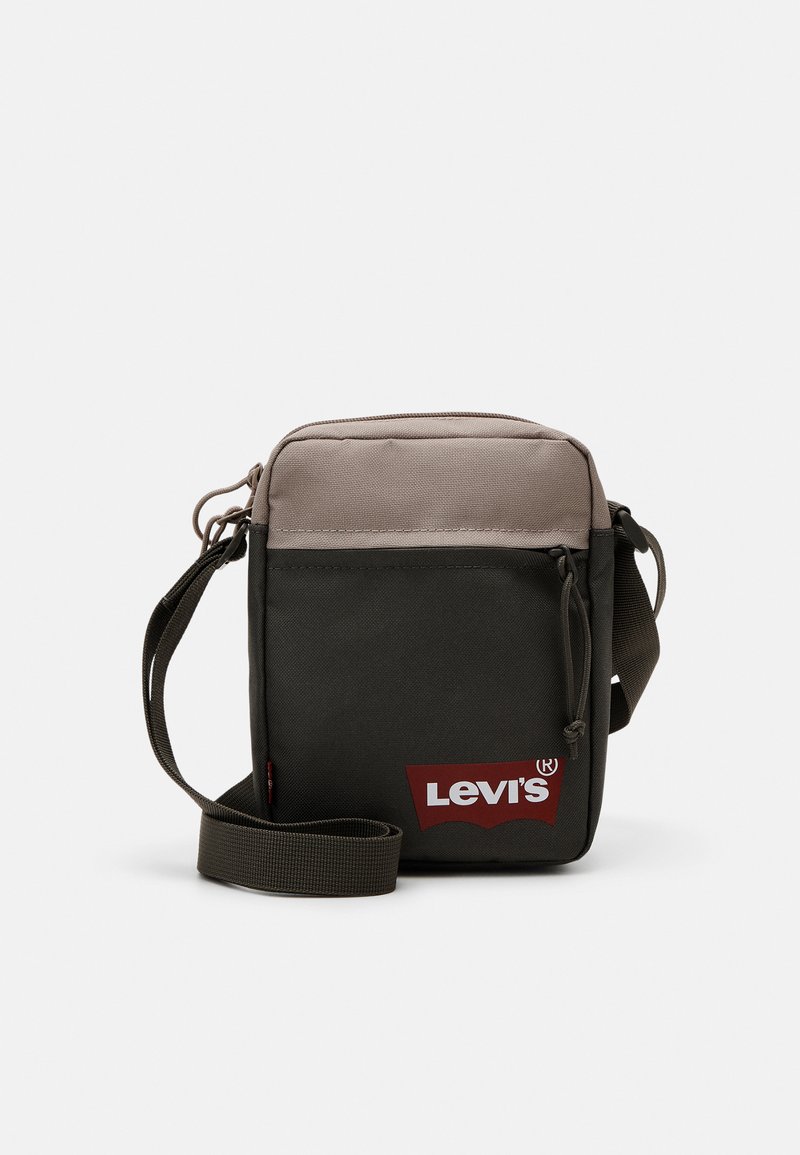 Geantă de umăr pătrată, de culoare verde măslin, cu partea superioară bej, curea ajustabilă, închidere cu fermoar și logo roșu Levi's pe partea din față. Fabrică durabilă.