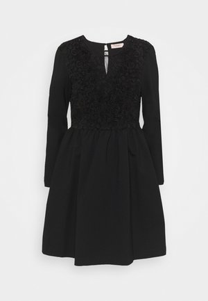 Black long-sleeve dress with lace detailing on the bodice and a slight keyhole neckline, flared skirt, and round collar.