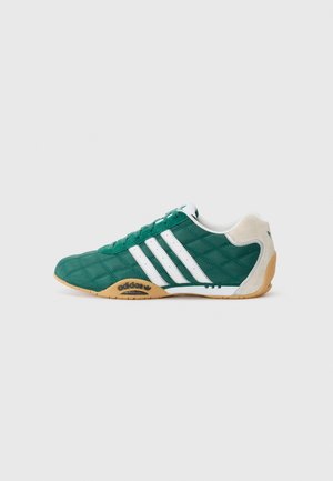 Sneakers verdi trapuntati con strisce bianche laterali, suola in gomma, collo imbottito e accenti blu. Progettati per un utilizzo casual e comfort.