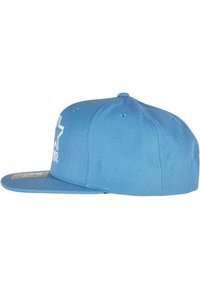 Blauwe honkbalpet met een platte rand, gemaakt van gestructureerde stof. Heeft een wit sterrenlogo aan de voorkant en ventilatieopeningen aan de zijkanten.