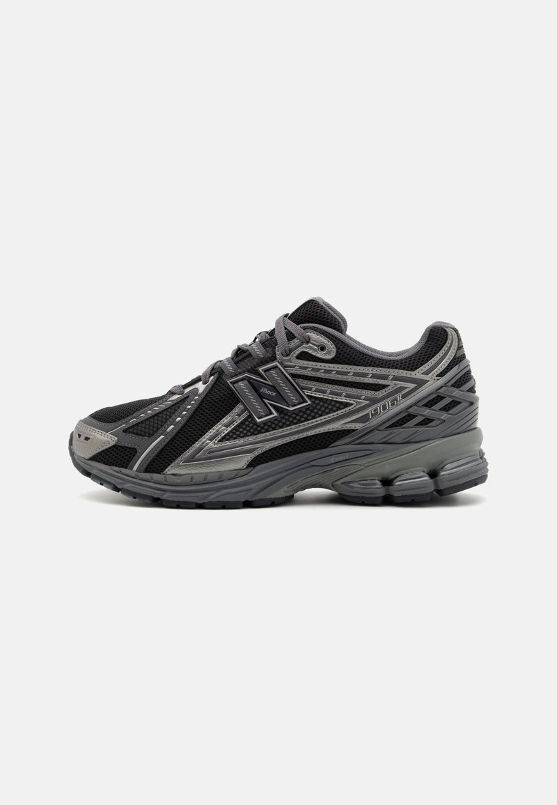 Chaussure de course New Balance noire et grise avec empeigne en mesh, semelle texturée, lacets et logo sur le côté, vue de l'extérieur.