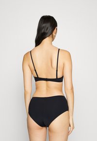 Zwarte bikini in twee delen met dunne bandjes. De top heeft een rechte achterkant en een sluiting met haakje, terwijl de onderkant een hoge taille heeft. Gladde textuur.