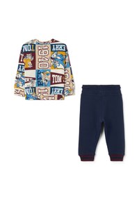 Camisa de manga larga de algodón con un diseño de parcheo de dibujos animados colorido en beige, combinada con pantalones de cintura elástica azul marino con detalles rojos.