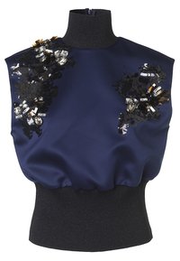 Marinblus i satin med hög svart ribbad krage. Har dekorerade svarta blommor med paljetter och kristaller på ena axeln.