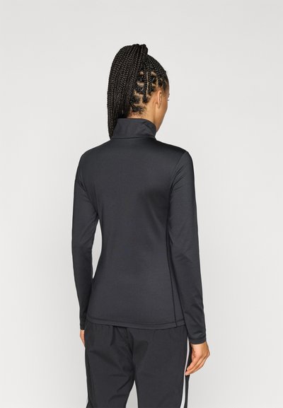 Camisa desportiva preta de mangas longas com colarinho alto, feita de um material liso e elástico, apresentando costuras mínimas e um design ajustado.