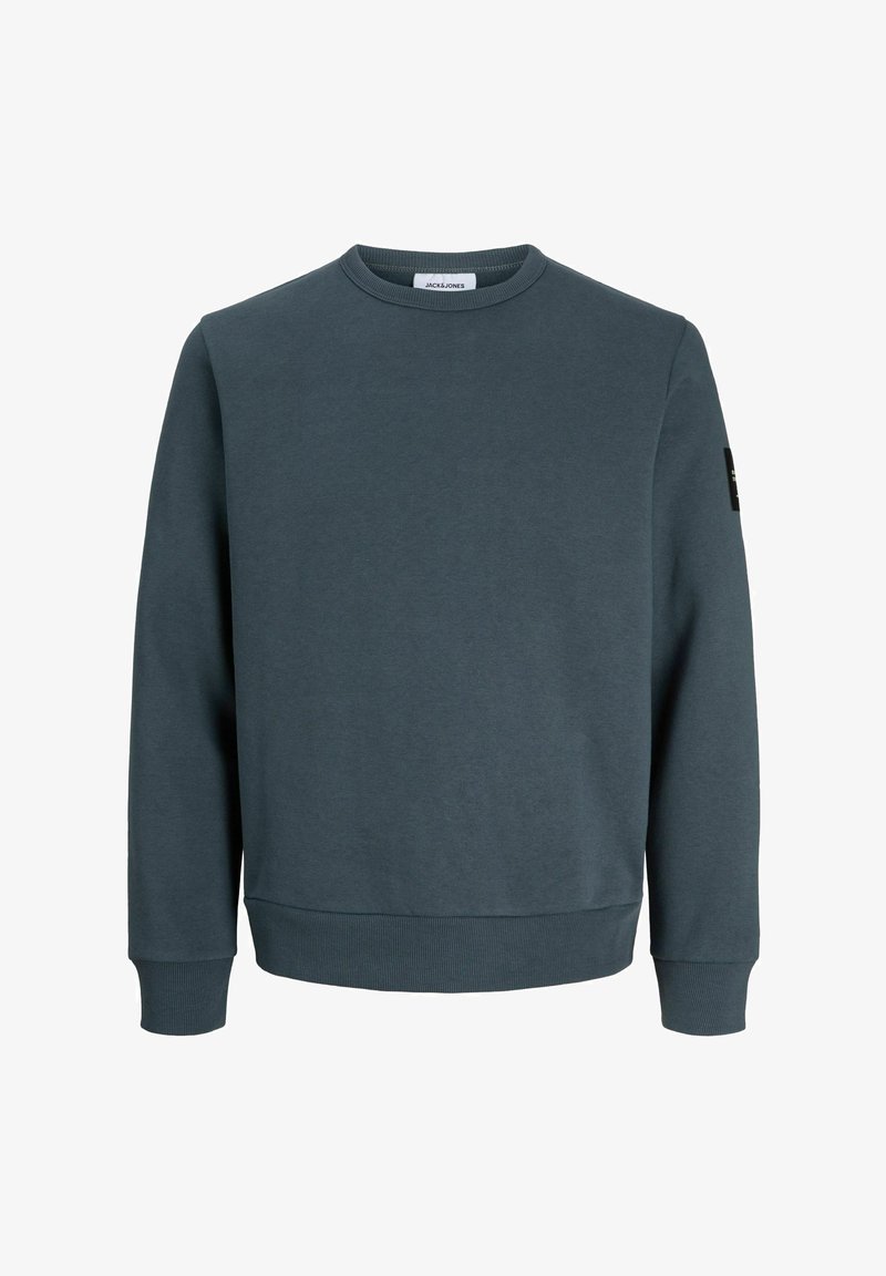 Sweat-shirt bleu foncé à col rond, manches longues, poignets et ourlet côtelés, avec un petit patch noir sur le haut du bras gauche.