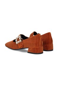 Zapatos de terciopelo naranja con textura acanalada, punta afilada, tacón bajo y cuadrado, y una hebilla decorativa con acentos transparentes.