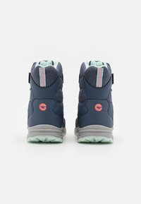 Marineblauwe hoge schoenen met een gestructureerde stoffen bovenkant, muntgroene accenten, roze logo detail en een grijze rubberen zool met grippatronen.