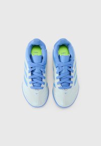 Zapatillas deportivas de color azul claro con una textura suave, que presentan acentos verdes, cordones azules y tres patrones de rayas a cada lado.
