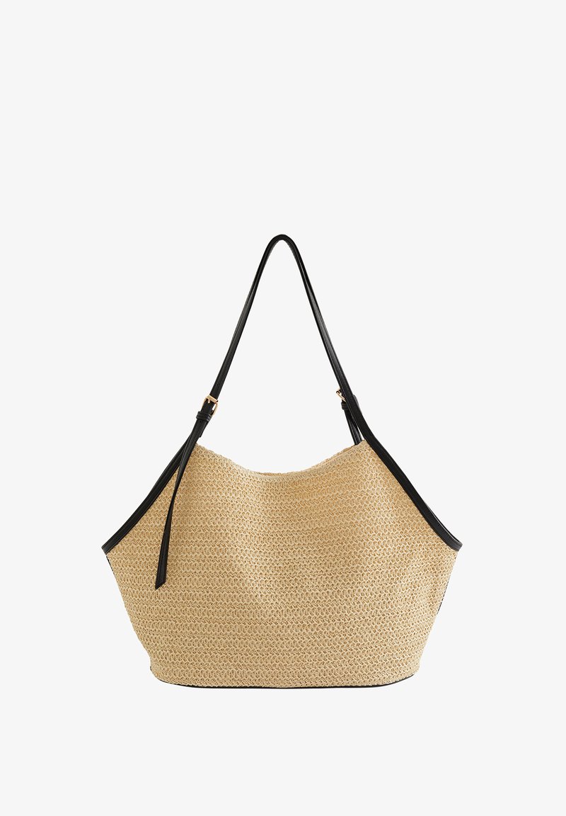 Grand sac cabas en paille tissée avec garniture en cuir noir et bretelles réglables, présenté sur fond blanc.