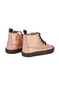 Botas de tobillo de cuero rosa con cordones negros, acabado texturizado, suela circular negra y una lengüeta de tiro trasera; presenta una cinta de Velcro en el costado.