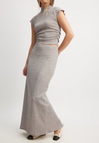 Siva rebrasta pletena dvodelna obleka, ki obsega prilegnjen zgornji del in dolgo krilo, z cap rokavi in gladko teksturo.