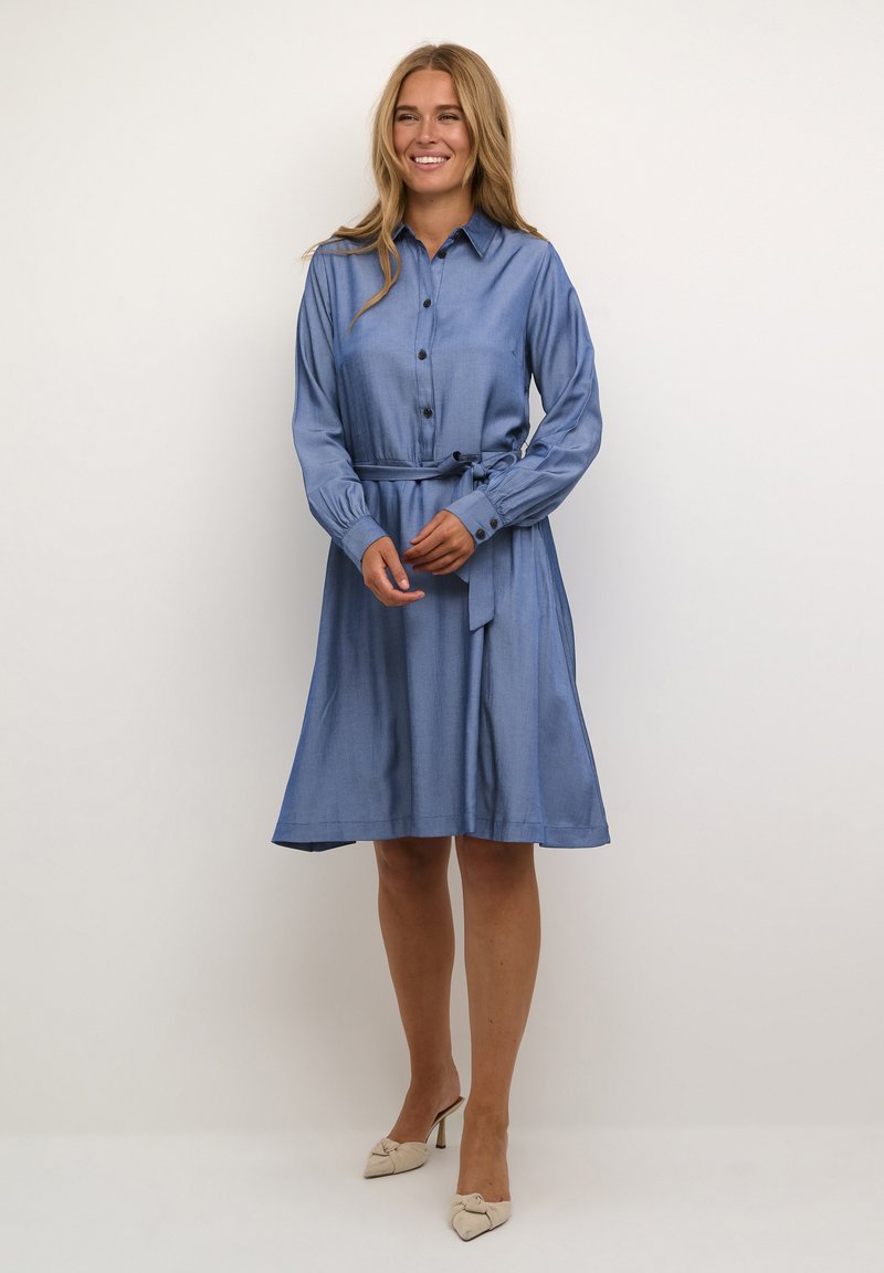 Helles Blau, knöpfbares Kleid mit langen Ärmeln und tailliertem Gürtel, ausgestattet mit einem ausgestellten Rock und weichem, strukturiertem Stoff.