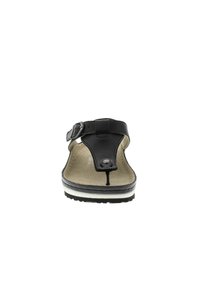Black sandal featuring a thong style with a buckle strap. The sole is light brown with a contrasting white stripe and black tread.