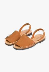 Brązowe zamszowe sandały z zamkniętym noskiem, otwartym tyłem i dwiema paskami. Posiadają kontrastowe białe przeszycia oraz płaską gumową podeszwę.