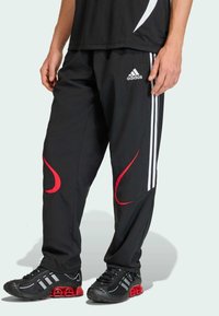 Melnas sporta bikses ar sarkanajiem akcentu izliekumiem, ar trim baltām svītrām sānos un logotipu priekšpusē. Viegls audums.