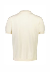 Kortärmad krämfärgad polo skjorta tillverkad av mjukt stickat tyg, med en ribbad krage och texturerade detaljer på axlarna.