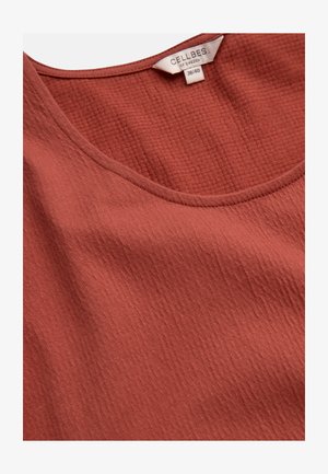 Rustfarvet tekstureret stofbluse med rund halsudskæring og påsyet label med teksten "Cellbes of Sweden 38/40."