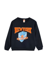 Sudadera negra con la palabra "NEW YORK" en texto naranja, un gráfico de un escudo azul con un balón de baloncesto, y puños y dobladillo acanalados.