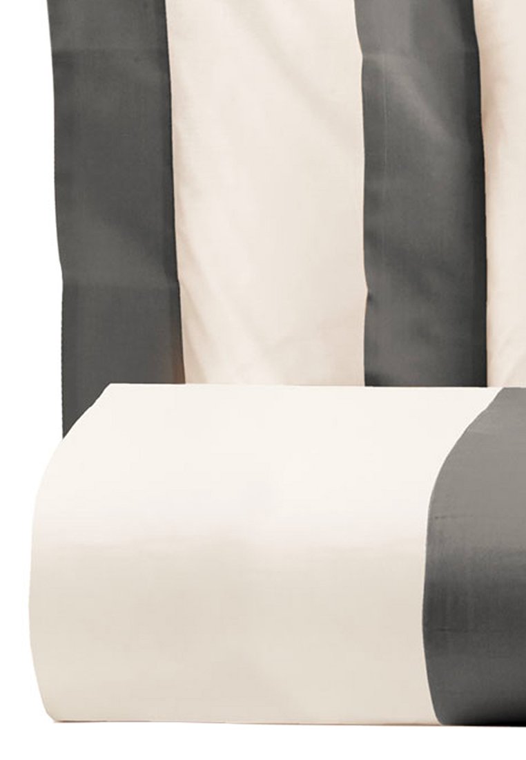 Tessuto piegato beige e grigio scuro a righe, probabilmente biancheria da letto o tende, mostrato da vicino con righe verticali e orizzontali ben definite.