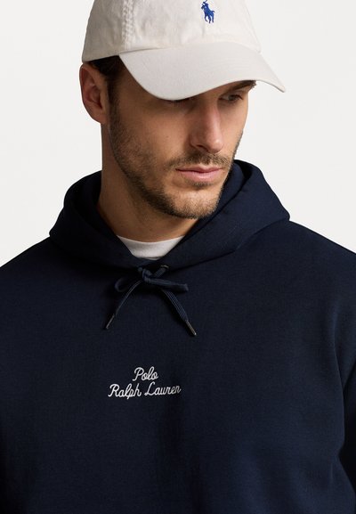 Jūrinės laivynas hoody su raišteliu, su baltu siuvinėjimu "Polo Ralph Lauren" logotipu. Audinys yra tekstūruotas, dažnai naudojamas kasdieniuose drabužiuose.