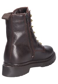 Bota de tobillo de cuero marrón con cremallera lateral, ojales en tono dorado, acabado texturizado, suela de goma gruesa y una lengüeta en la parte posterior.