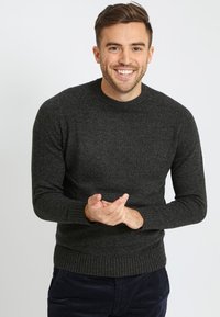 Dunkelgrauer Strickpullover mit rundem Ausschnitt, gerippten Bündchen und Saum, mit strukturiertem Stoff und figurbetontem Schnitt.