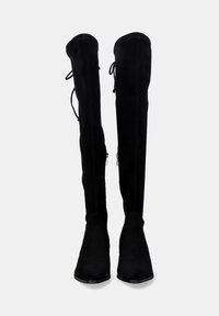 Botas negras sobre la rodilla hechas de suave ante. Cuentan con una punta afilada, tacón plano y cordones ajustables en la parte posterior para un mejor ajuste.