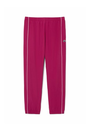 Magenta trainingsbroek met witte strepen aan de zijkant, elastische taille en manchetten, en een klein groen krokodillenlogo op de rechterdij.