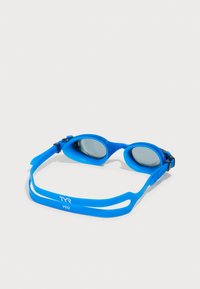 Gafas de natación con un brillante marco de silicona azul, correa ajustable y lentes tintados. Presenta la marca TYR y un diseño aerodinámico.