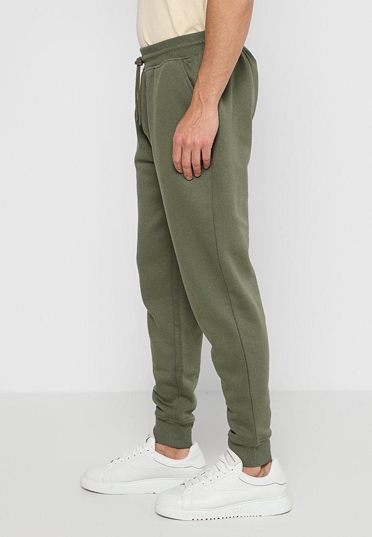 Joggers verde oliva realizzati in tessuto morbido, con vestibilità affusolata, vita elastica con cordoncino e tasche laterali.