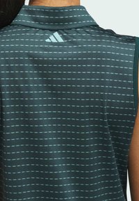 Ærmeløs top i mørkegrøn stof med fine vandrette striber i lyseblå. Krave-design med Adidas-logo på ryggen.