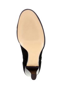 Bottine en daim noir avec un bout pointu, une semelle texturée et un accent en cuir contrastant. Présente une silhouette épurée et un marquage minimaliste.