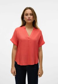 Blusa corta corallo maniche a corto con scollo a V e colletto sottile, realizzata in tessuto leggero, caratterizzata da una vestibilità rilassata e un orlo curvo.