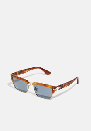 Óculos de sol em tartaruga com lentes azuis, formato retangular, acabamentos em metal na armação e design texturizado nas hastes.