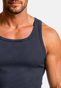 Granatowy top w paski z okrągłym dekoltem i szerokimi ramiączkami, wykonany z gładkiego, elastycznego materiału, podkreślający umięśnioną sylwetkę.