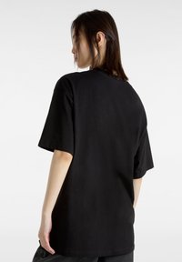 T-shirt nera in cotone con maniche corte e scollatura a girocollo, caratterizzata da una vestibilità comoda e dettagli minimi.