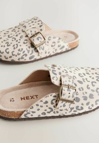Ciabatte a stampa leopardata con tomaia in suede beige, dotate di una fibbia metallica e una suola in gomma testurizzata. Logo del marchio stampato all'interno.
