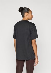 Μαύρο t-shirt με κοντά μανίκια, ίσια κοπή και μαλακή υφή. Διαθέτει στρογγυλή λαιμόκοψη και ελάχιστες λεπτομέρειες στο πίσω μέρος.