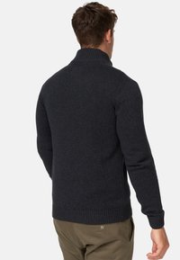 Pull gris foncé avec un col haut, des poignets et un ourlet côtelés, et un motif en tricot texturé. Convient pour un usage décontracté.