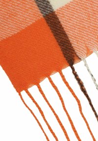 Woven scarf featuring an orange, cream, and brown check pattern with fringed edges and a soft texture.