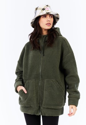 Groene fleece zip-up hoodie met textuurstof, oversized pasvorm en zijzakken. Gecombineerd met een gestreepte witte bucket hat.