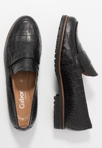 Mocassins en cuir noir avec un motif crocodile, semelles intérieures rembourrées, des panneaux latéraux élastiques et des semelles en caoutchouc texturé pour une meilleure adhérence.
