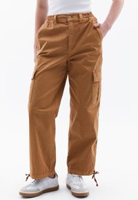 Cargo-pantalons in een tan kleur, met een elastische tailleband, zijzakken en een relaxte pasvorm. Gemaakt van lichtgewicht, getextureerde stof.
