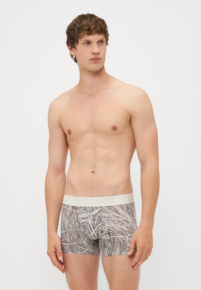 Męskie bokserki z jasnobeżowym pasem i wzorem w kamuflaż, składającym się z przytłumionych odcieni szarości i beżu. Miękka tkanina o dopasowanym kroju.