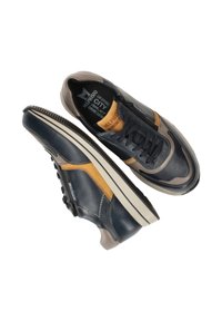 Leren sneakers in marineblauw, bruin en grijs. Beschikt over een ronde neus, vetersluiting en een gestructureerde rubberen zool met een opvallend profiel. Merken zichtbaar.