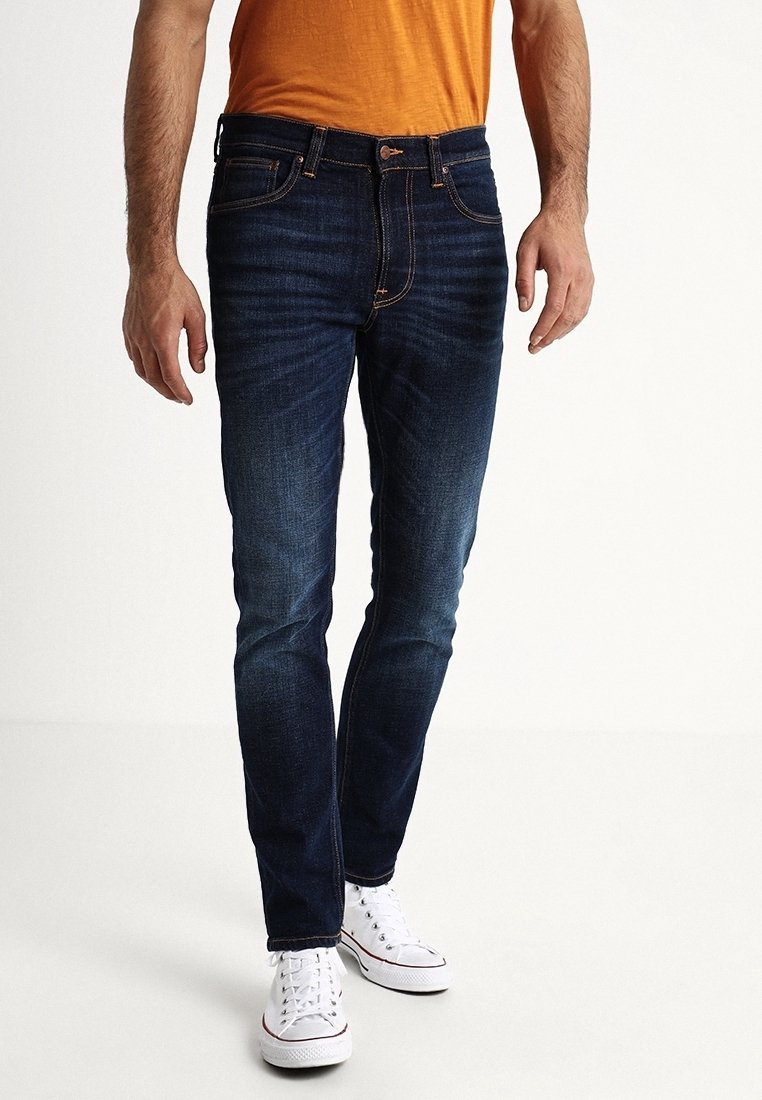 Mörkblå jeans med slim fit, med en klassisk femficksdesign och ljusa söms detaljer. Bärs tillsammans med vita sneakers.