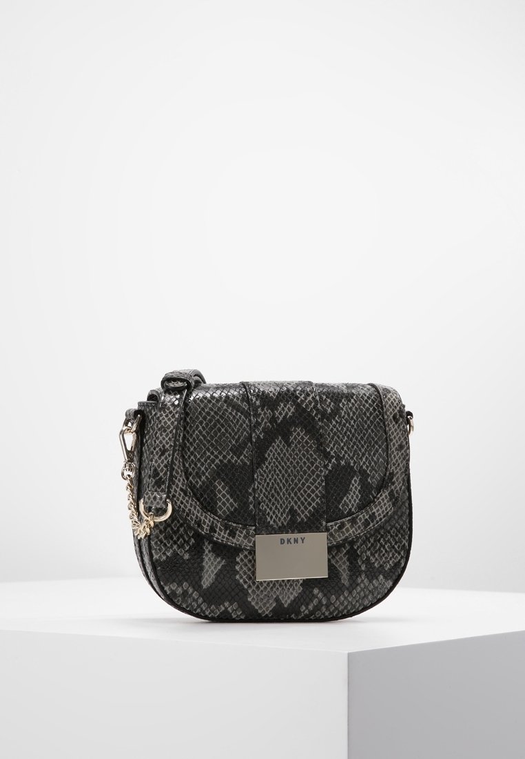 Přes rameno kabelka DKNY v černém a šedém hadím vzoru, vybavená klopovým zavíráním, stříbrným kováním a nastavitelným řetízkovým popruhem.