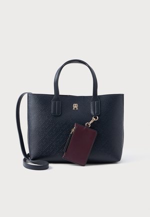 Borsa a spalla navy in materiale testurizzato con doppi manici e portafoglio bordò staccabile. Accento con logo dorato sul fronte. Inclusa tracolla regolabile.