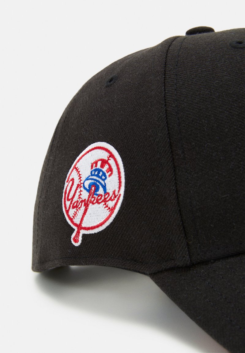 Gorra de béisbol negra con un logotipo de los Yankees bordado en blanco, letras rojas y un acento azul, hecha de un tejido texturado.